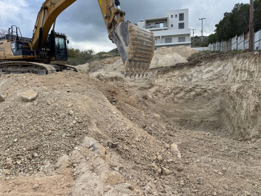 Excavating the plot with an excavator at the start of construction.