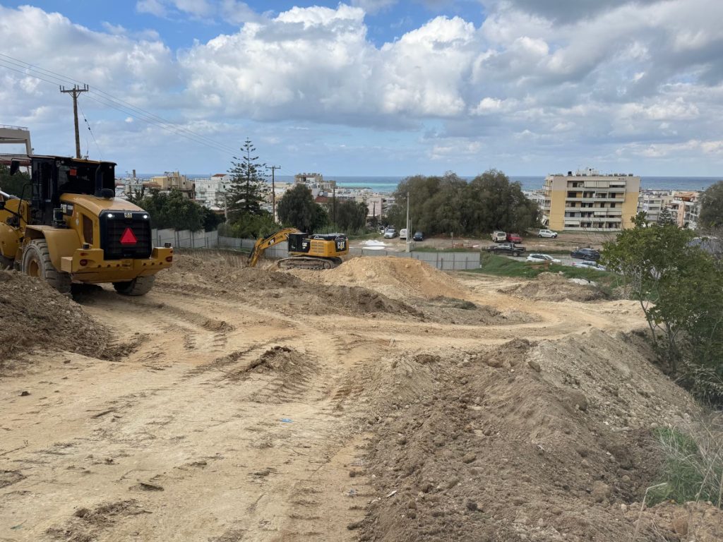 The plot during excavation, with the machinery and the sea in the background.