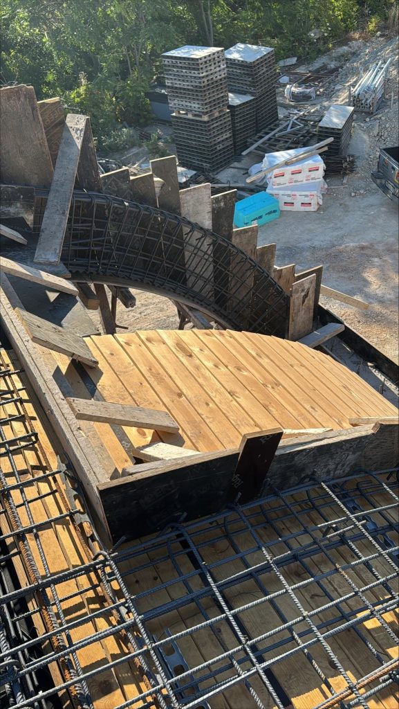 Curved formwork and reinforcement at a corner of the slab.