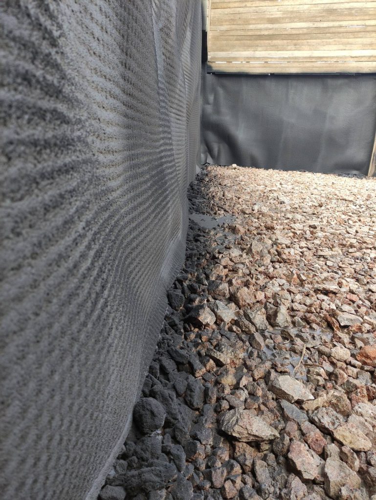 Close-up of the membrane around the edge of the pit, above the gravel layer.