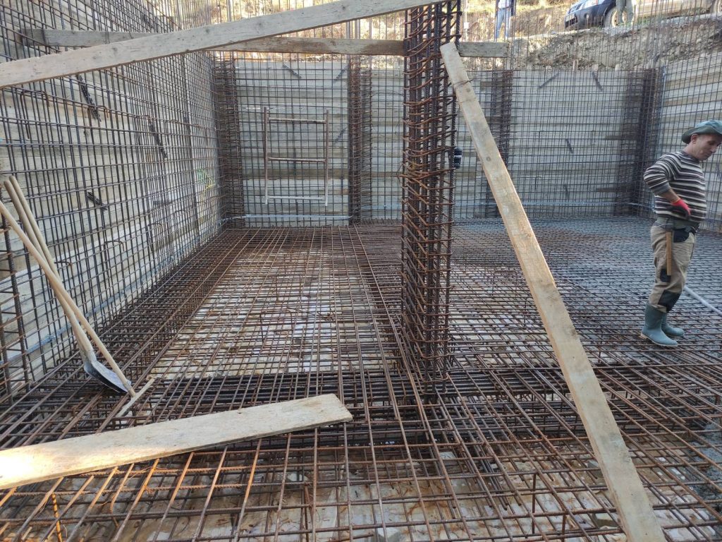 The reinforcement for the raft foundation and the basement walls, with the crew at work.
