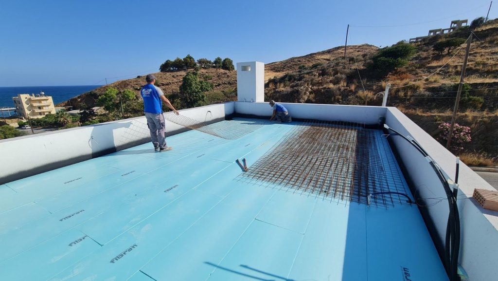 Insulation boards and mesh on the roof terrace, with a view of the sea.