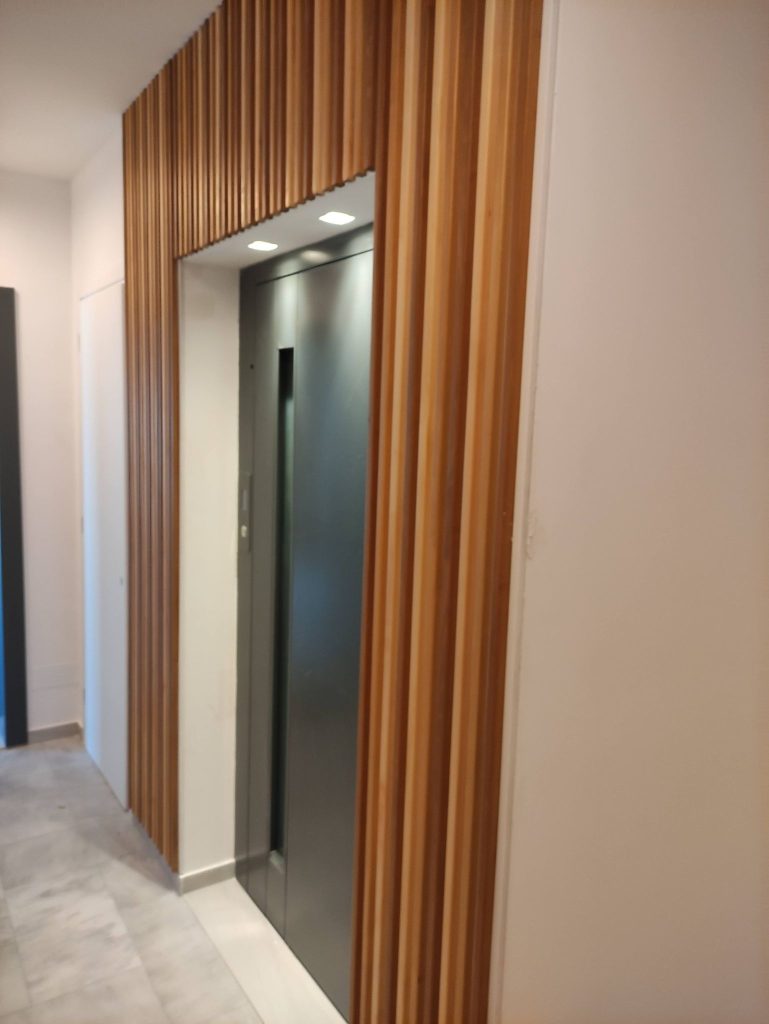 The lift entrance, framed with vertical timber slats.