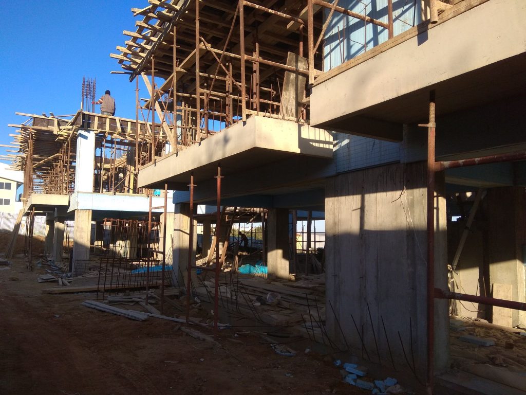 The load-bearing structure with the cantilevered balconies and the scaffolding.