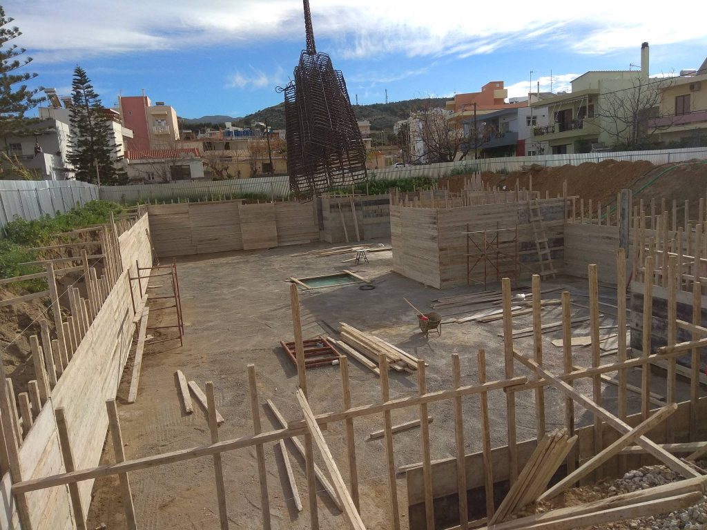 The formwork for the basement walls, with a reinforcement cage hanging from the crane.
