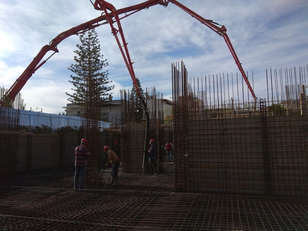A crew pouring the raft foundation, with the pump boom overhead.