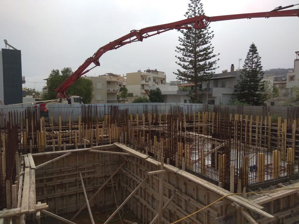 Pouring concrete for the basement walls and columns with a pump.