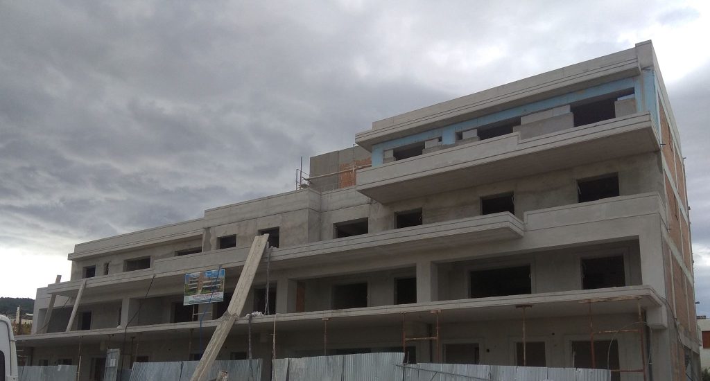 The building with its load-bearing structure and masonry complete, showing the upper-floor balconies.