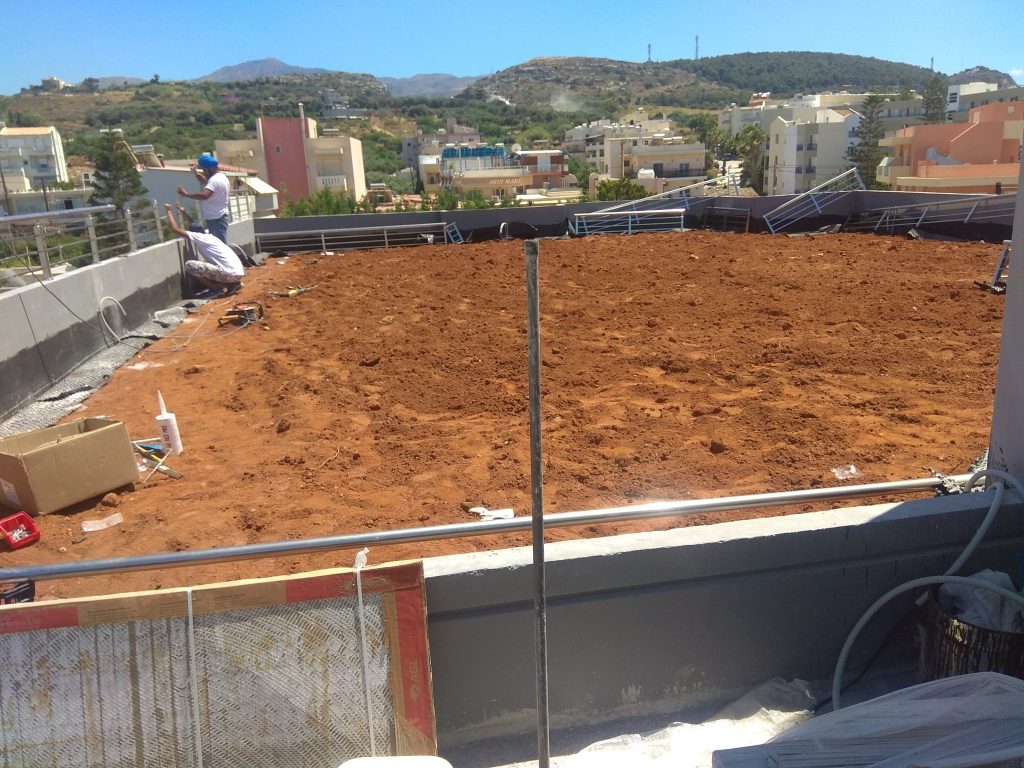 Spreading topsoil on the roof terrace before planting.