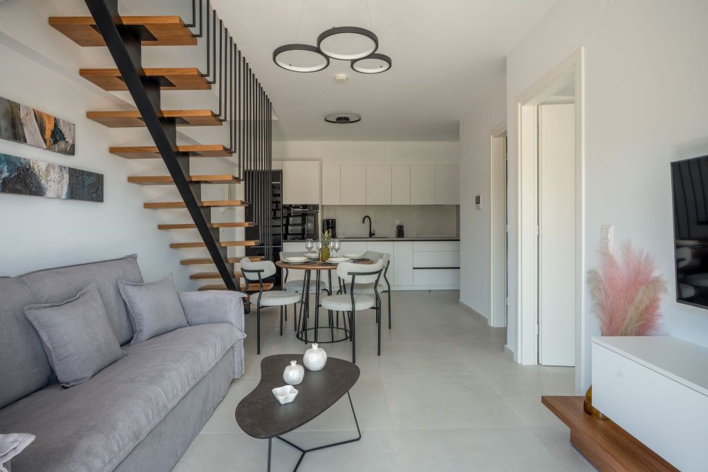 The open-plan living, dining and kitchen area, with the steel staircase and its timber treads.