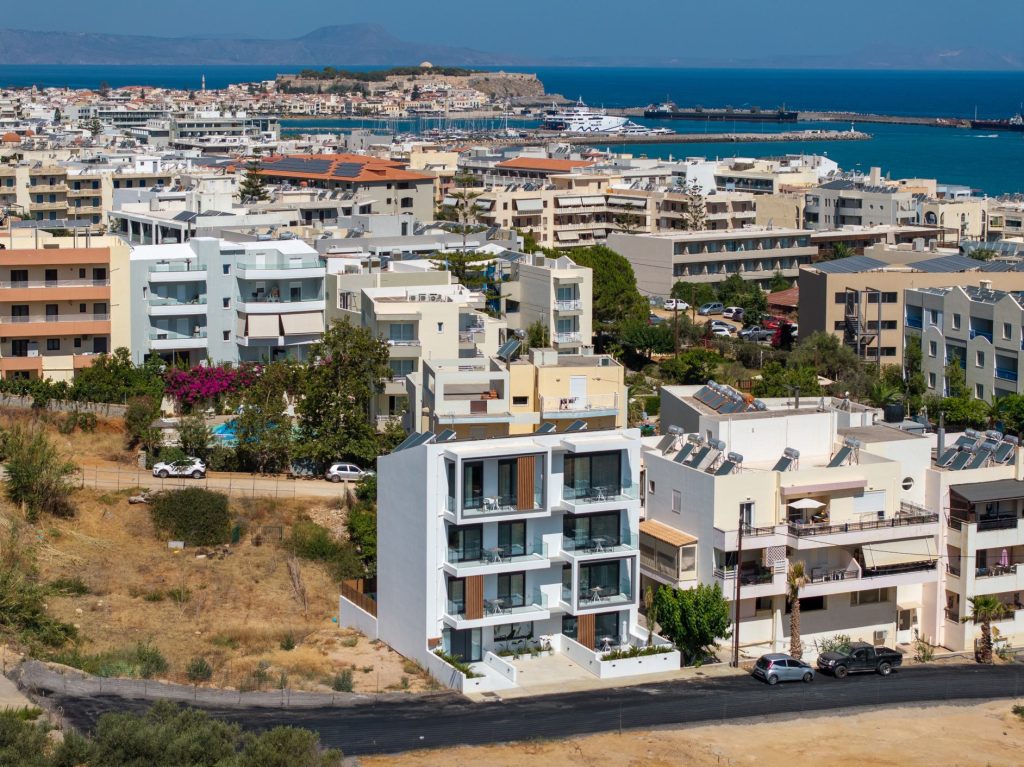Aerial photo of the building, with the town of Rethymno, the harbour and the Fortezza in the background.