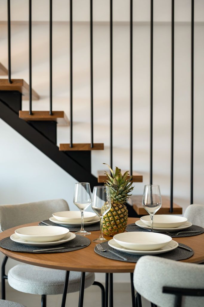 A round table laid for a meal beneath the suite's staircase.