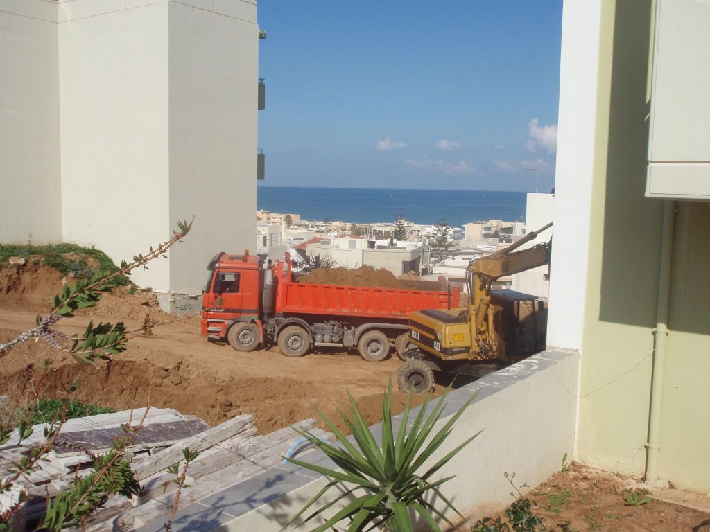 Removing the excavated soil, with the sea in the background.