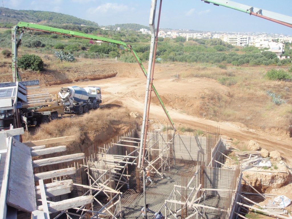 A concrete pump above the formwork, with the town in the background.