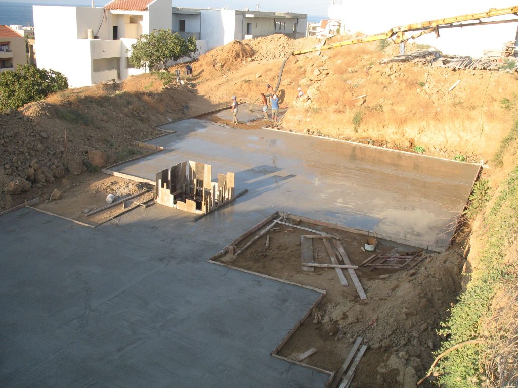The foundation after the concrete pour, with the concrete pump on the slope.