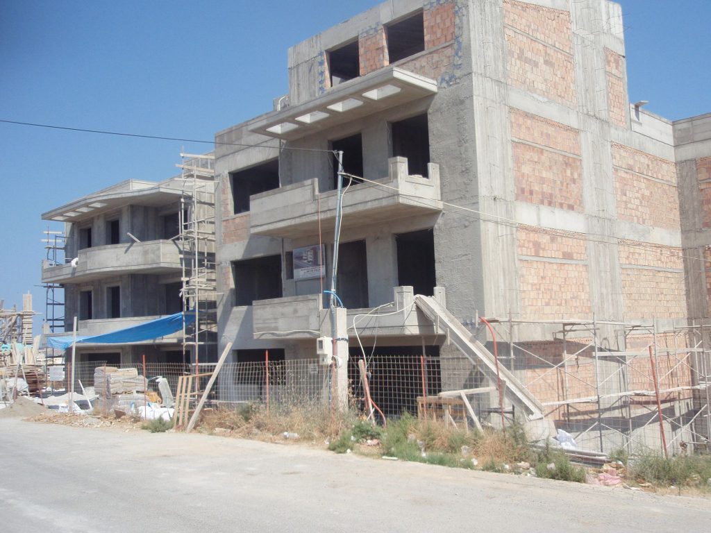 The load-bearing structure with the brick walls and scaffolding on the façades.