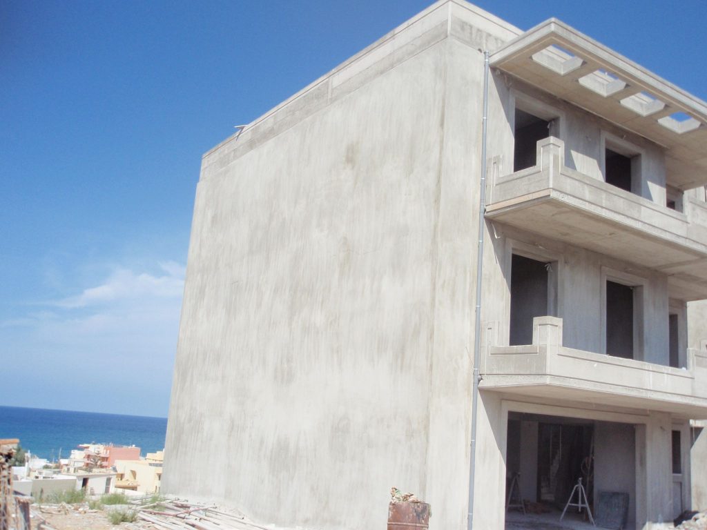 Plastering on the side façade, with the sea in the background.