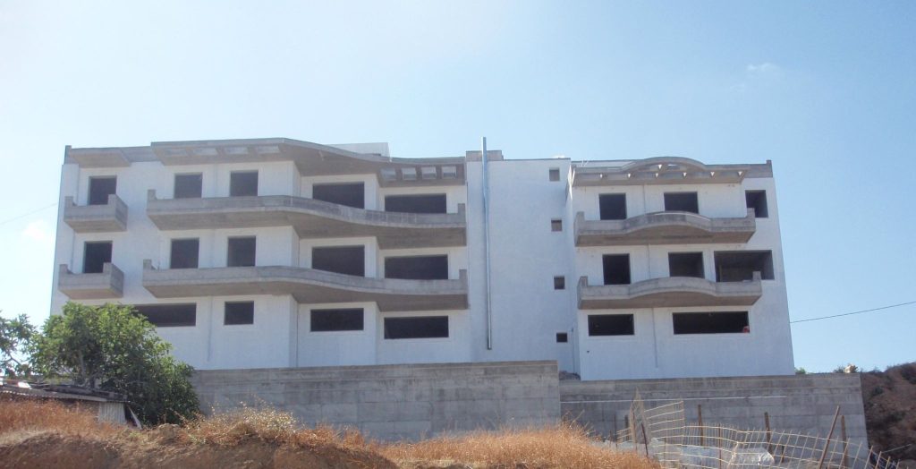 The whole front of the building with its curved balconies, before painting.