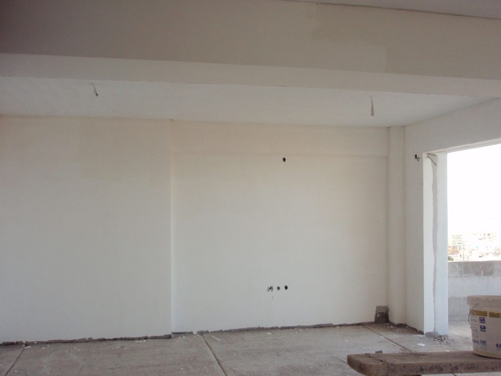 Inside an apartment after plastering, with the opening onto the balcony.