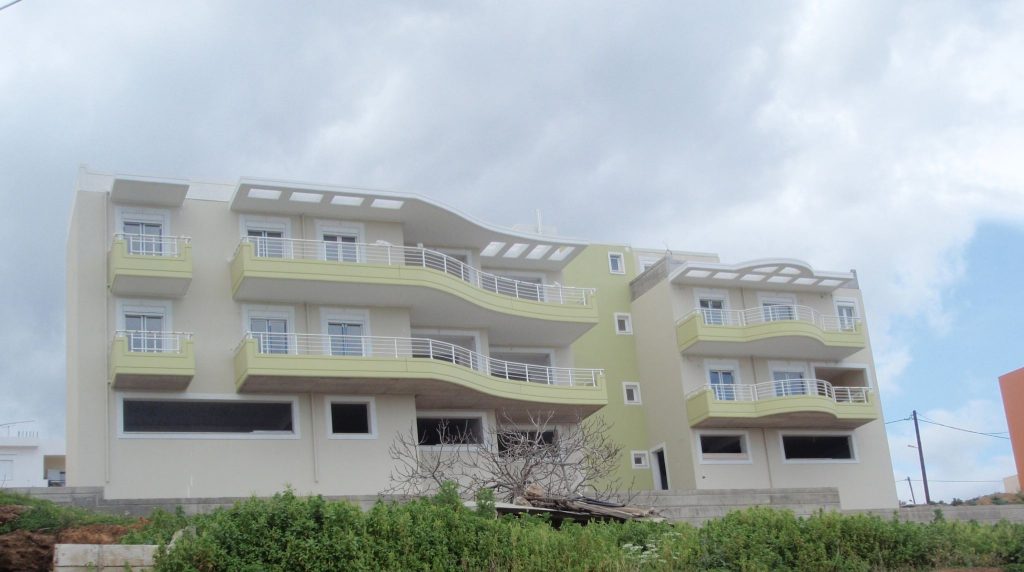 The front of the building with its curved balconies and the top-floor pergolas.