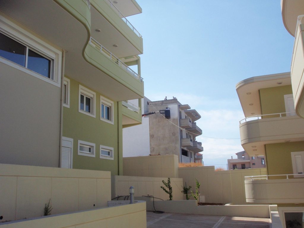 The paved area between the two buildings, with planters and the upper-floor balconies.