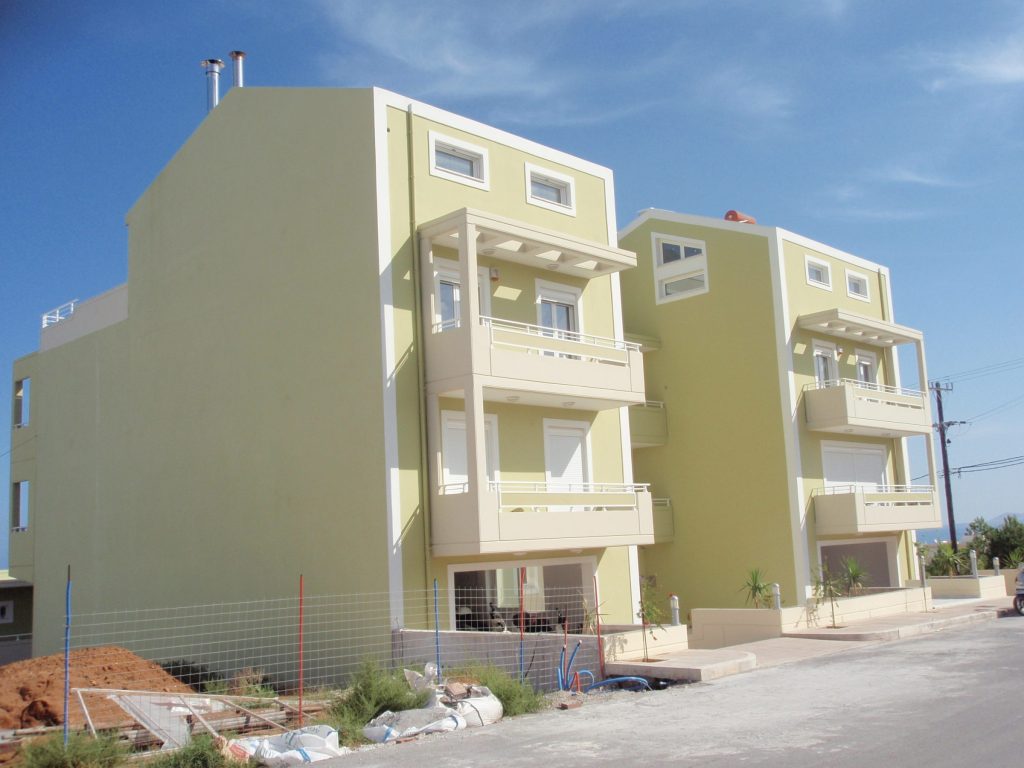 The two buildings of the complex from the street, with pergolas on the upper-floor balconies.