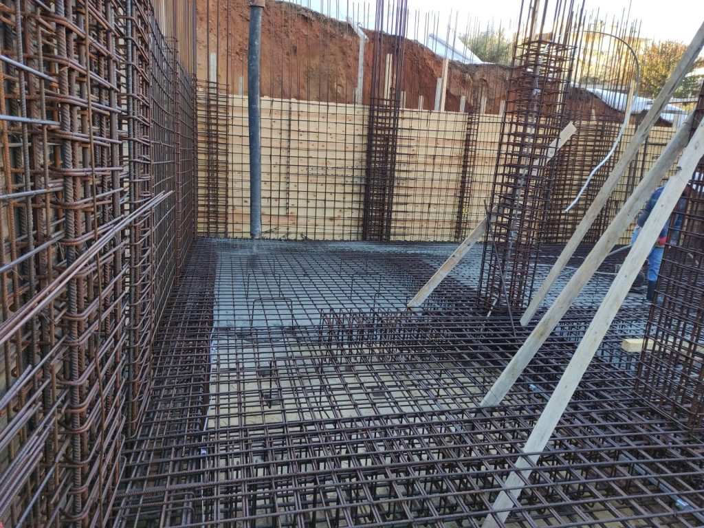 The reinforcement for the raft foundation and the basement walls, next to the formwork.
