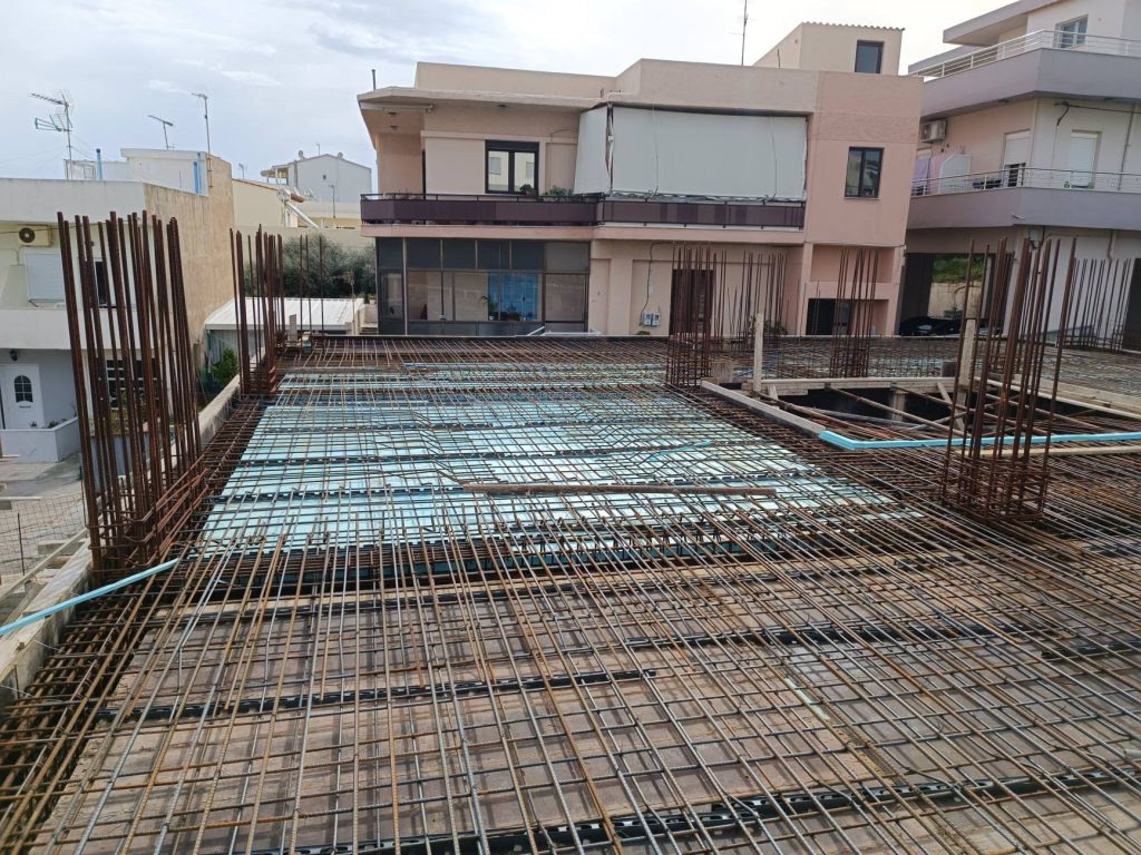 The slab reinforcement, with the column starter bars and the neighbouring houses around it.