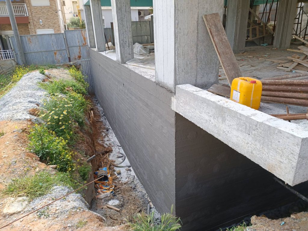 Waterproofing the basement walls before backfilling.
