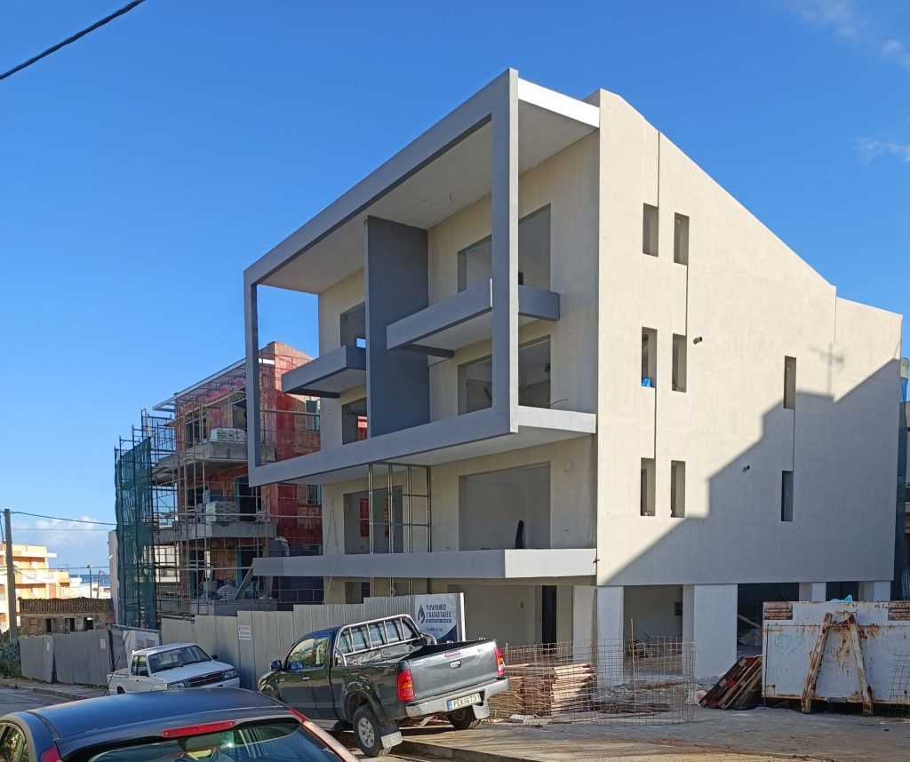 The front of the first building after plastering, with the second still under scaffolding.