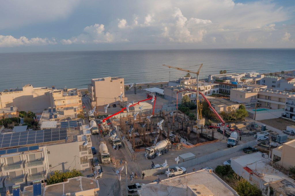 Aerial photo of the foundation pour with two pumps, with the sea in the background.