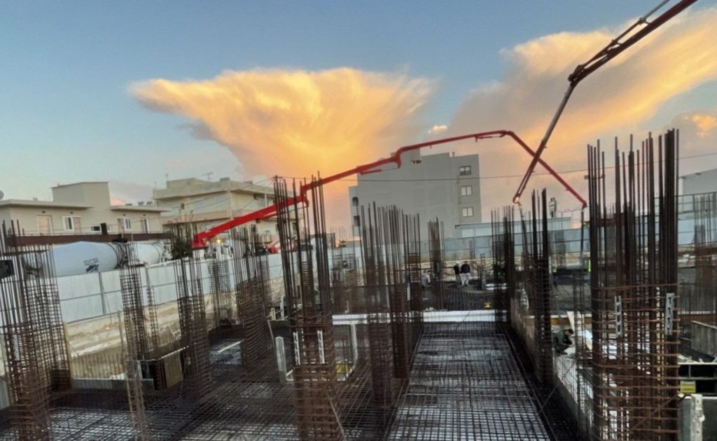 A concrete pump above the reinforcement, at sunset.