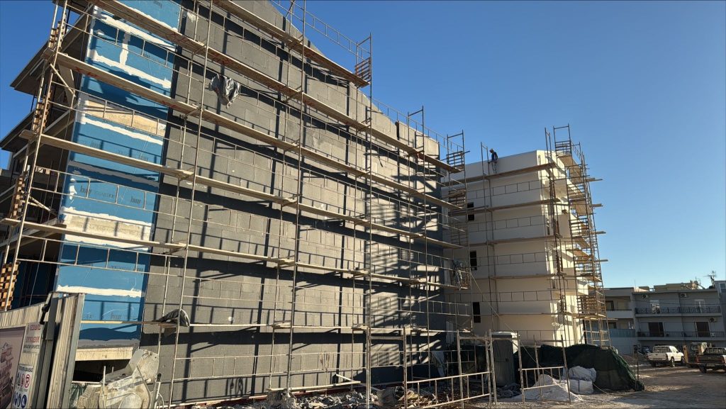 The façades with their insulation and scaffolding, seen from the street.
