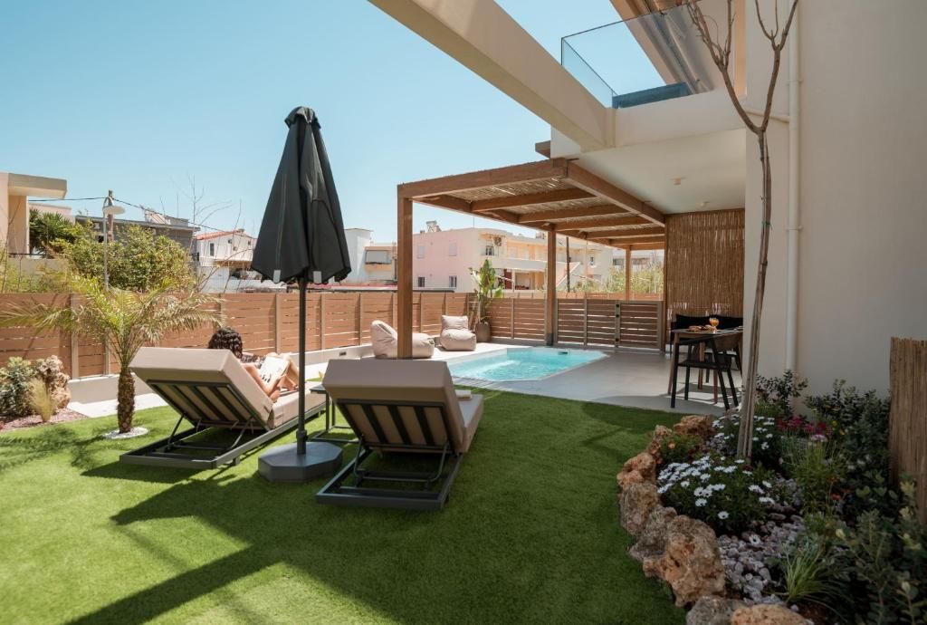 A private garden with lawn, sun loungers and a pool, next to the pergola.