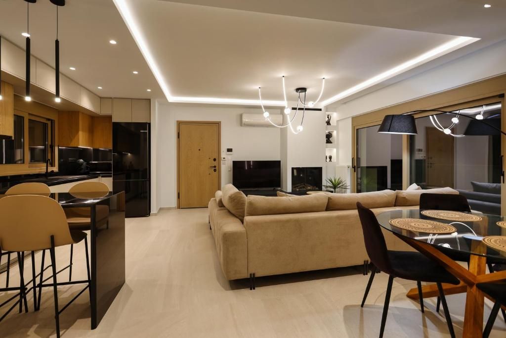 An open-plan living, dining and kitchen area, with concealed ceiling lighting.