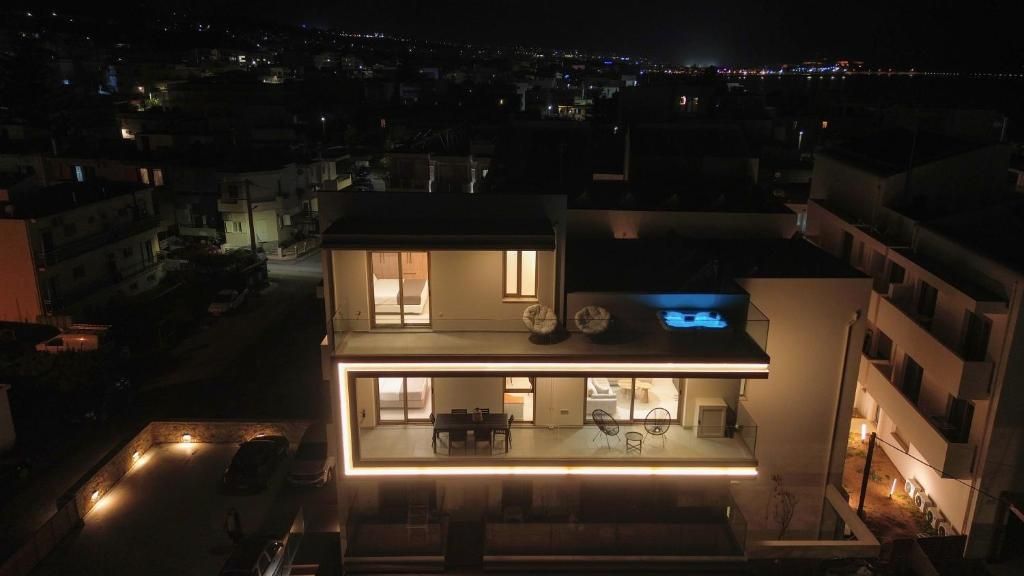 Aerial photo of the building at night, with the upper-floor balcony lit up.