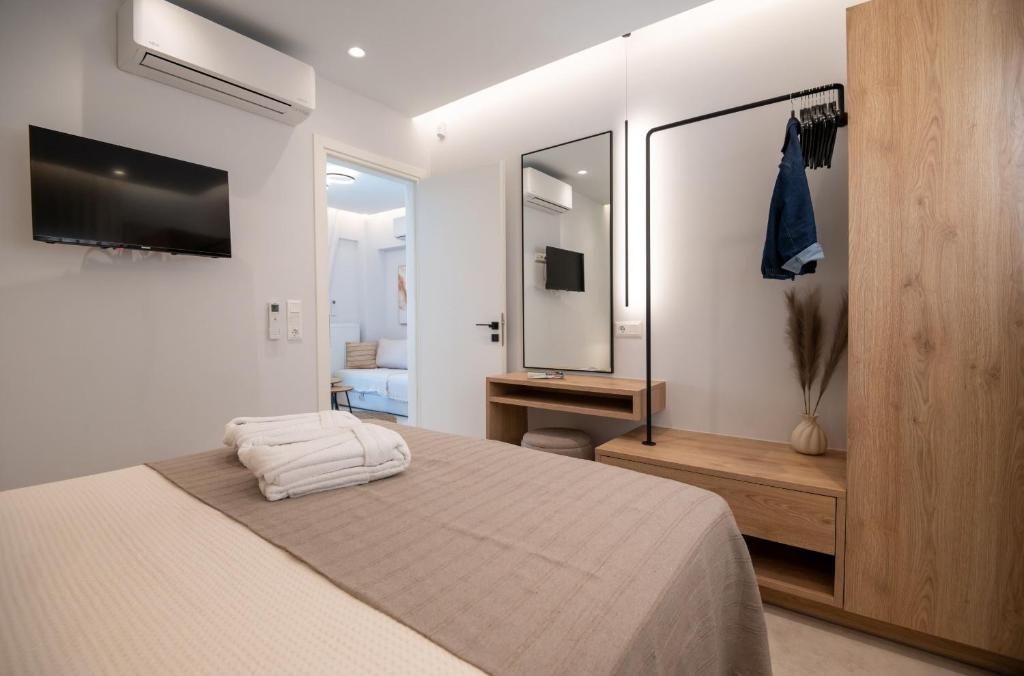 A bedroom with a wooden wardrobe, a mirror and a door to the living room.