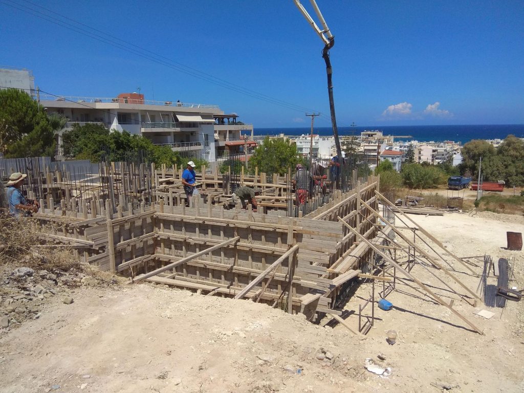 The ground-floor formwork above the basement, with the concrete pump and the sea in the background.